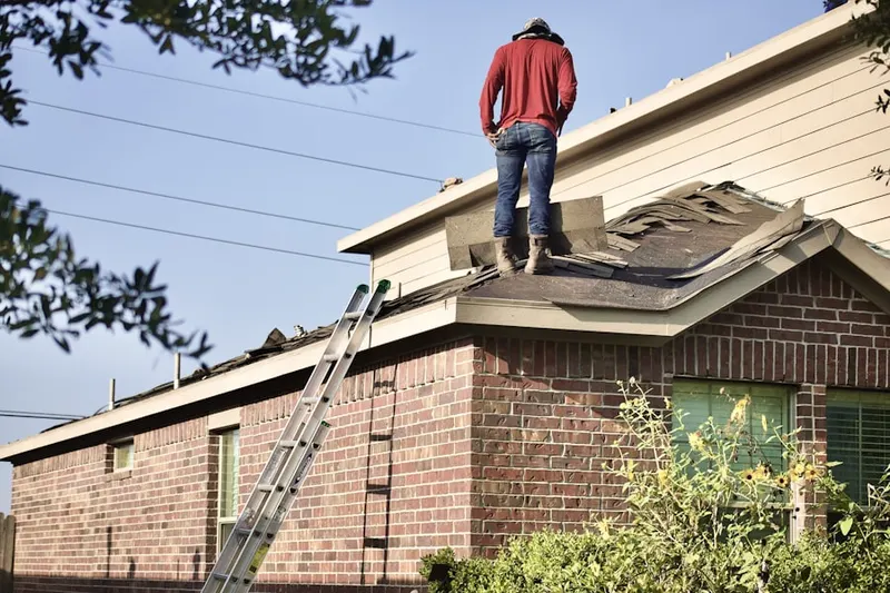 Professional roofer working on a residential roof in Roxbury
